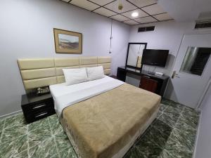 sypialnia z dużym łóżkiem i telewizorem w obiekcie West Hotel w Dubaju