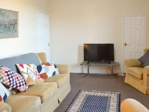 a living room with two couches and a flat screen tv at Marleys Retreat in Seaton Delaval