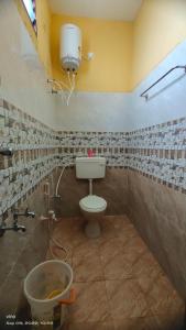 a bathroom with a toilet and a bucket in it at Aadhya guest house in Tiruvannāmalai