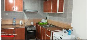 a kitchen with wooden cabinets and a sink and a stove at Apartment in Ajman,Studio flat in Ajman 