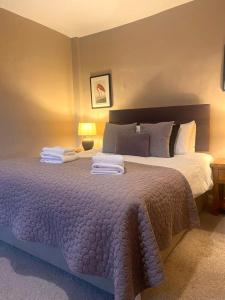1 dormitorio con 1 cama grande y toallas. en The Chequers Inn, en Froggatt