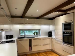 a kitchen with white cabinets and a window at Villa Männituka külalistemaja in Kirikuküla