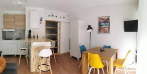 een keuken en eetkamer met een tafel en gele stoelen bij Gourette appartement près des pistes, Résidence Val Soleil, 256 Gourette Nord, rue de Tortes in Eaux-Bonnes