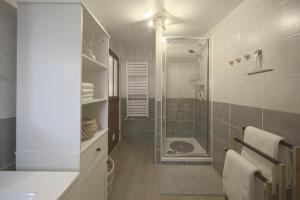 a white bathroom with a shower and a sink at L'Eldorado - By BEST KEYS - Idéal Pros, Couple & Famille - 1 Chambre et 1 Canapé-Lit Convertible - Cosy & Confort - Centre Ville - Netflix & WiFi Fibre - Machine à Café Nespresso - Check-in Autonome - Parking Facile & Gratuit in Sens +9 photos