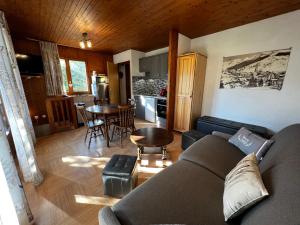 ein Wohnzimmer mit einem Sofa und einer Küche in der Unterkunft Abricot - Appart dans chalet in La Clusaz
