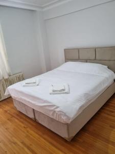 a bed with white sheets and two plates on it at Erdem Apartment in Atakum