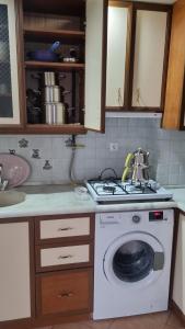a kitchen with a stove and a washing machine at Erdem Apartment in Atakum