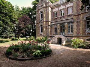 an old building with a garden in front of it at Mille et une feuilles in Saint-Martin-lez-Tatinghem