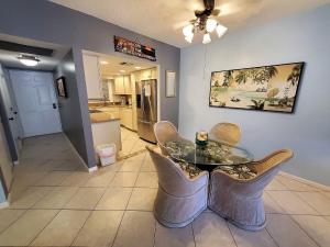 Un comedor con una mesa de cristal y sillas. en Welcome to Oasis #21 Your Coastal Retreat in Daytona Beach Shores-Walk To The Beach, en Daytona Beach Shores 11 fotos más