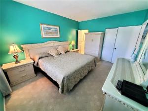 Un dormitorio con una cama y una pared verde. en Welcome to Oasis #21 Your Coastal Retreat in Daytona Beach Shores-Walk To The Beach, en Daytona Beach Shores