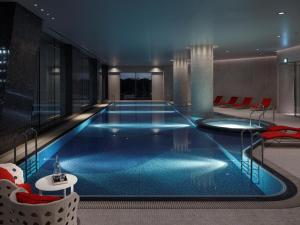 a large swimming pool in a hotel with red chairs at Palace Hotel Tokyo in Tokyo