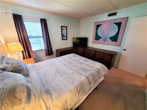 Un dormitorio con una cama y un televisor. en Oasis #7 Coastal Escape in Daytona Beach Shores-Walk To The Beach, en Daytona Beach Shores 9 fotos más