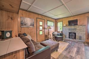 sala de estar con sofá y chimenea en Comfy Burt Lake Abode - On-Site Lake Access!, 