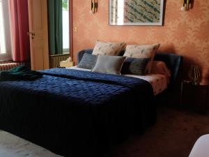 Schlafzimmer mit einem Bett mit blauer Bettwäsche und Kissen in der Unterkunft Mille et une feuilles in Saint-Martin-lez-Tatinghem