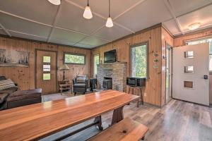 a living room with a wooden table and a fireplace at Comfy Burt Lake Abode - On-Site Lake Access! 