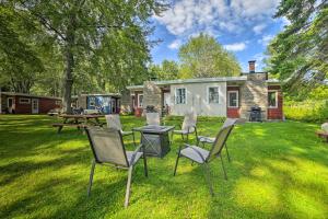 a group of chairs and a table in a yard at Comfy Burt Lake Abode - On-Site Lake Access! 