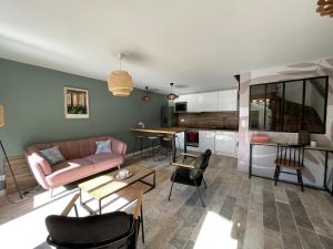 ein Wohnzimmer mit einem Sofa und einem Tisch in der Unterkunft Maison chaleureuse sous les pins in Seignosse