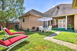 um quintal com uma mesa e cadeiras e um guarda-sol em Welcoming New Orleans Home Near Bourbon St! em Nova Orleães