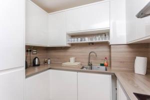 a kitchen with white cabinets and a sink at Spacious 2 Bedroom Flat on Bermondsey St in London