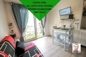 um quarto com um sofá, uma mesa e uma televisão em Au petit repère palois -studio - centre ville-balcon-WIFI FIBRE em Pau