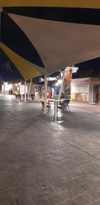 a patio with a table and benches under a large umbrella at Studio apartment, Aqua View Resort, North coast in El Alamein