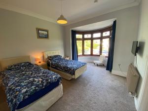 a bedroom with two beds and a window at Newport Kenvor Dinas Cross Easy access bungalow near beaches in Dinas