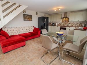 a living room with a red couch and a glass table at Top Lodge in Llanvair Discoed