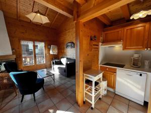 eine Küche und ein Wohnzimmer eines Blockhauses in der Unterkunft Murgiers B1 - Chalet mitoyen in La Clusaz