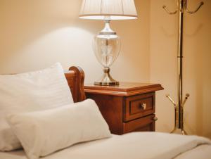 a lamp sitting on a table next to a bed at Casa Botisa - Luxury Villa with private pool in Kumanovo