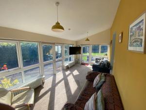 a living room with a couch and some windows at Newport Kenvor Dinas Cross Easy access bungalow near beaches in Dinas