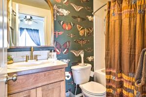 a bathroom with a toilet and a sink with butterflies on the wall at Prismatic Boise Retreat with Fenced Backyard! in Boise +17 photos