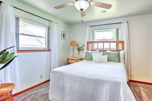 1 Schlafzimmer mit einem weißen Bett und 2 Fenstern in der Unterkunft Woodward Home Near Crystal Beach Water Park! in Woodward