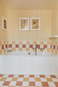 a large bath tub in a room with tiles at Hôtel Bienvenue in Paris