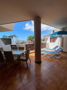 een balkon met een tafel en stoelen en een parasol bij Albatros Golf & Sea View in San Miguel de Abona