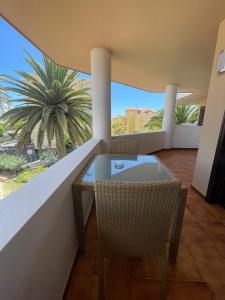 een balkon met een tafel en stoelen en een palmboom bij Albatros Golf & Sea View in San Miguel de Abona