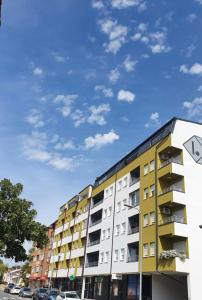 a yellow apartment building with a blue sky in the background at XENA apartment Gradiška in Bosanska Gradiška