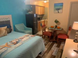 a bedroom with a bed and a kitchen with a table at Michaels Siesta Studios in Redington Shores