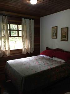 Schlafzimmer mit einem Bett und einem Fenster in der Unterkunft Casa de campo em Monte Verde , linda vista para montanhas in Monte Verde