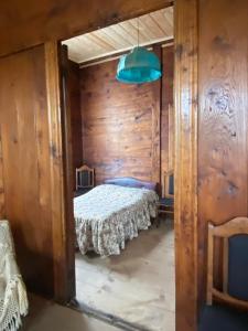 a bedroom with a bed in a wooden wall at გურული ეზო*Gurian yard in Chala