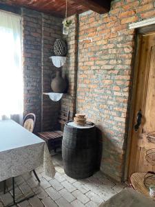 a patio with a barrel and a table and a brick wall at გურული ეზო*Gurian yard in Chala +24 photos