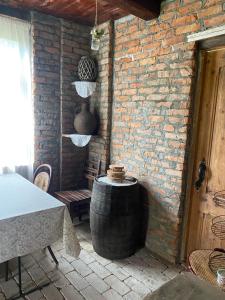 a patio with a barrel and a table and a brick wall at გურული ეზო*Gurian yard in Chala