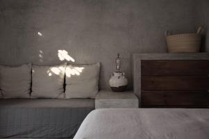 Cette chambre comprend un lit avec des draps blancs et une commode. dans l'établissement Desierto Azul, à Todos Santos