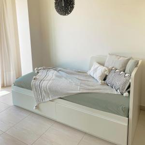 a bed with a white bed frame with pillows on it at Kleos suite in Bari