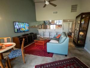 a living room with a blue couch and a tv at Desert Dream in Palm Desert