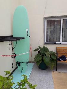 a blue surfboard leaning against a wall next to a plant at Casa Afonso Guesthouse in Ferrel
