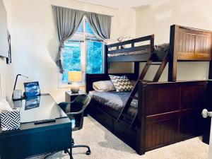 a bedroom with a bunk bed with a desk and a desk at Diamond Adventure Slope Side with Foosball and Arcade at Wintergreen Resort in Wintergreen