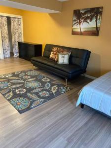 uma sala de estar com um sofá de couro preto e um tapete em River getaway Downstairs unit em Bullhead City