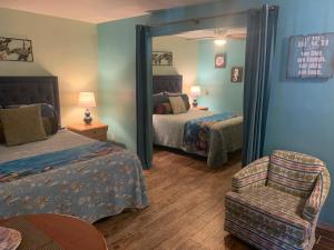 a bedroom with two beds and a mirror and a chair at Michaels Siesta Studios in Redington Shores