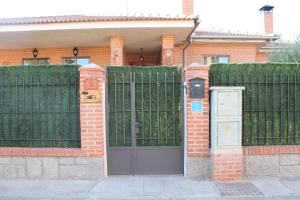 una puerta frente a una casa con una valla en Aire De Pinares, en Coca
