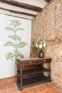 a wooden table in a room with a stone wall at Menta Rural in San Pedro Sallavinera